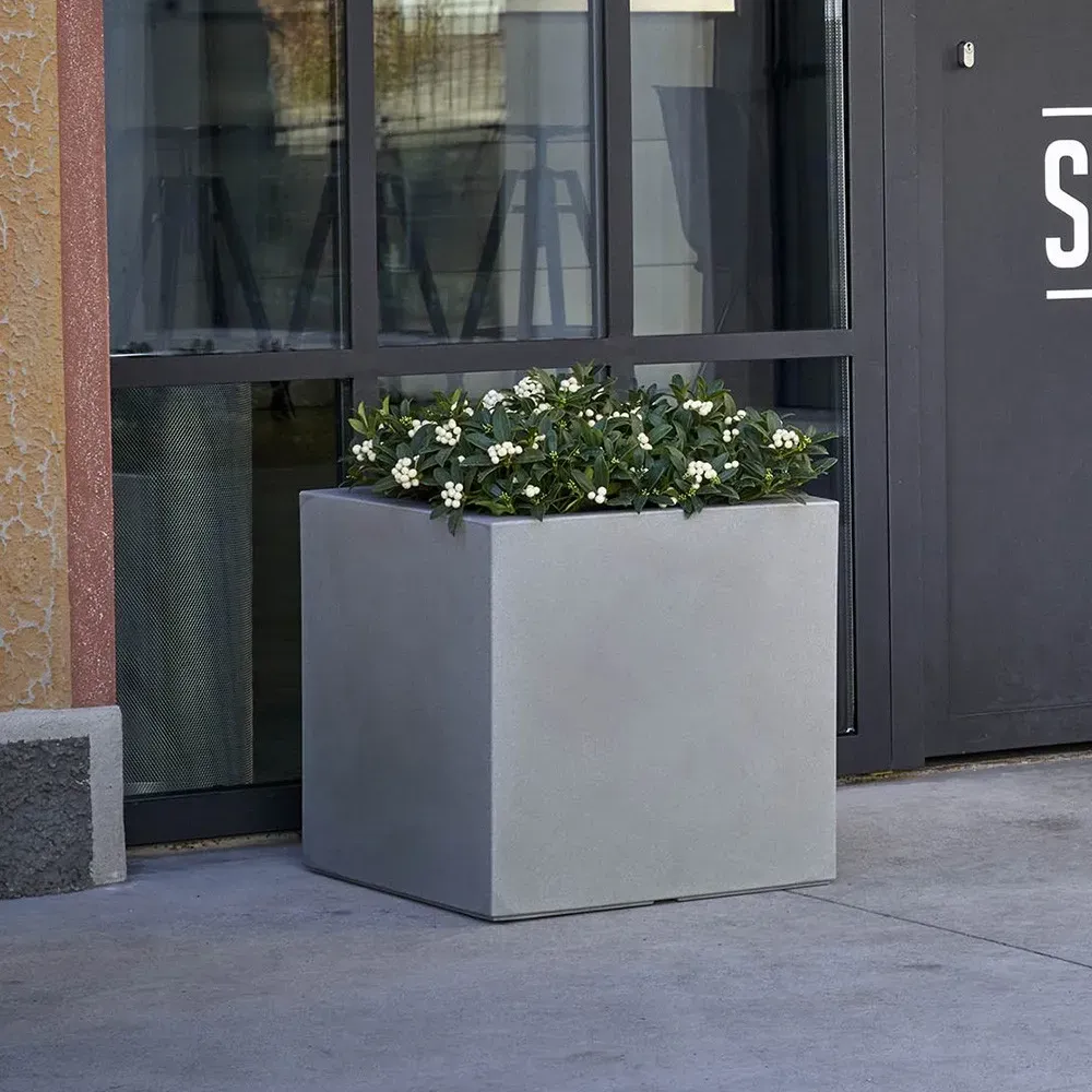 Kleiner KUBE Pflanzkasten mit Rollen und kleiner Grünbepflanzung im Außenbereich